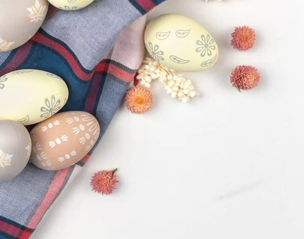 Çiçekli Paskalya yumurtaları. Mutlu tatiller, beyaz bir arka planda kutlama ve selamlama tasarımı. Düz, üst görünüm ve boşluk kopyala 