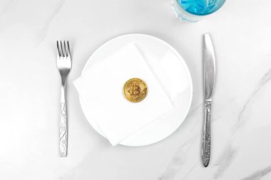 Bitcoin altın para konsepti. Kripto para birimi karışık medya görüntüsü. Beyaz bir tabakta bitcoin servis ettim. Mermer arkaplan fotoğrafı