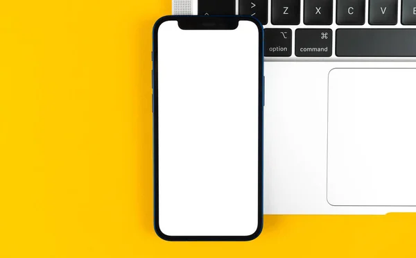 Pantalla de maqueta de Apple iPhone, escritorio de oficina plano con computadora portátil, fondo amarillo. Diseño mínimo, maqueta de teléfono móvil, vista superior, espacio para copiar — Foto de Stock