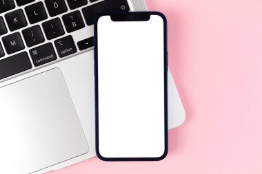 Apple iPhone 'un düz ekran modeli, dizüstü bilgisayarlı ofis masaüstü, parlak pembe arkaplan. Üst görünüm, uzay fotoğrafını kopyala