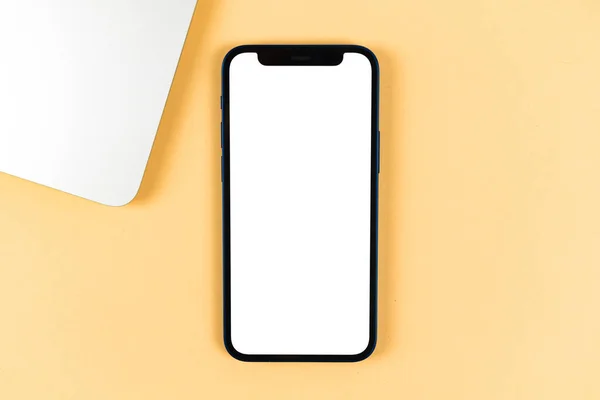 Flat lay Apple iPhone maqueta, escritorio de oficina con ordenador portátil, fondo beige brillante. Vista superior, copiar espacio foto — Foto de Stock