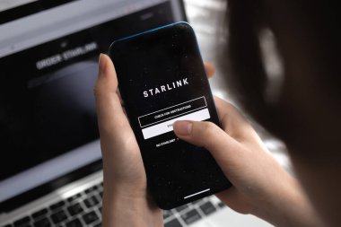 Poltava, Ukrayna - 26 Mart 2022: Cep telefonunda Starlink uygulaması kullanan kadın, Elon Musk Internet 