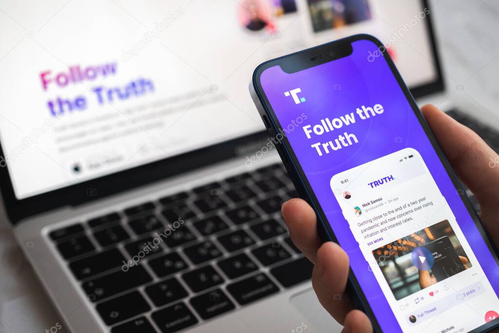Poltava, Ukraine - March 23, 2022: Woman using Truth Social application on the mobile phone close-up logo photo