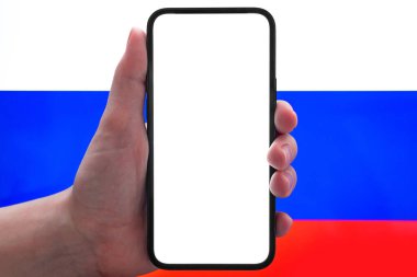 Rus bayrağı arka planında cep telefonu modelleme ekranı olan bir el. Metin, uygulama bilgisi vs. için maket, kopyalama alanı 