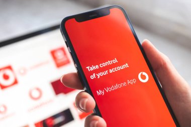 Vodafone uygulamam. Mobil ağın başlık ekranlı cep telefonu kadının elinde