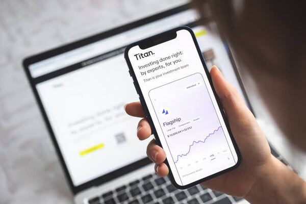 Poltava, Ukraine - April 5, 2022: Woman use Titan invest app. Mobile phone banking and investment concept photo