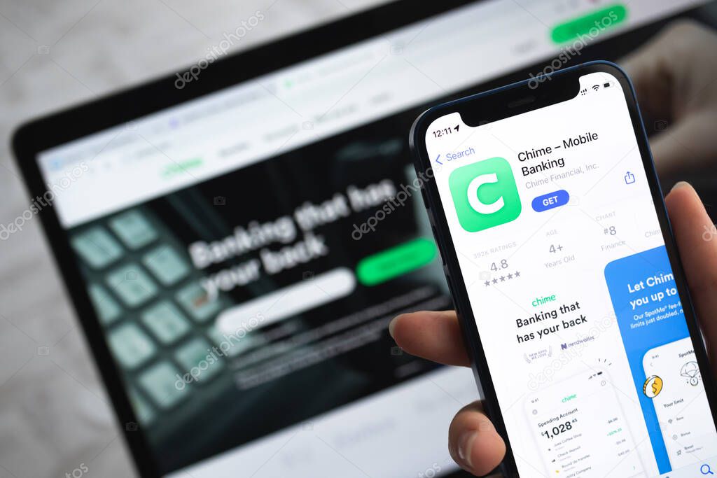 Poltava, Ukraine - April 5, 2022: Chime app icon. Hand with mobile phone with application. Mobile banking and investment concept