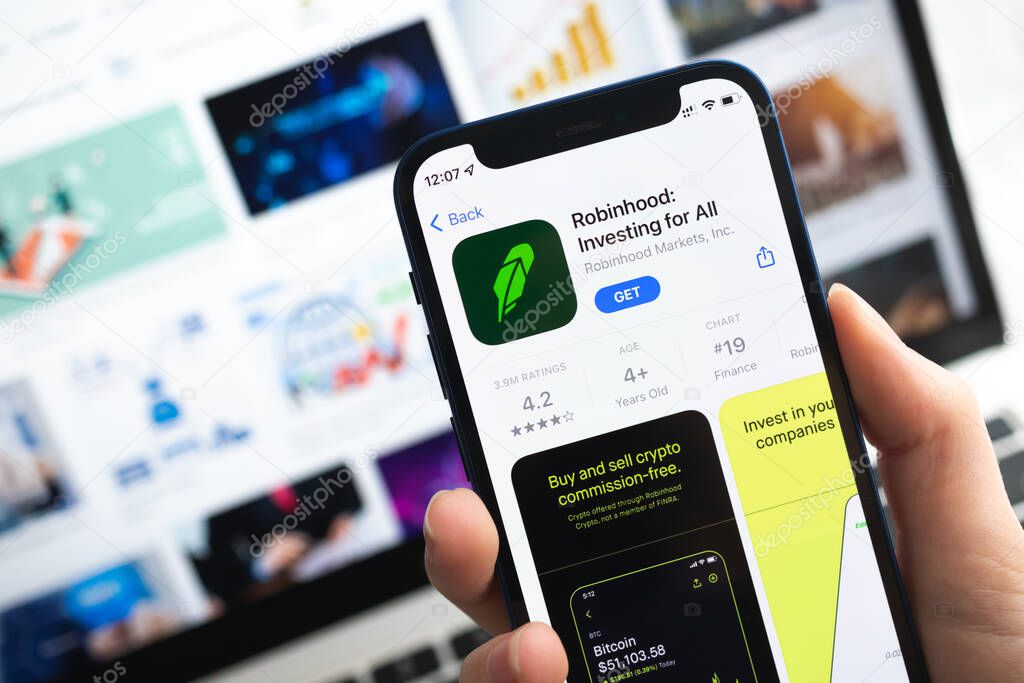 Poltava, Ukraine - April 5, 2022: Robinhood Investing app icon. Hand with mobile phone with application. Mobile banking and investment concept