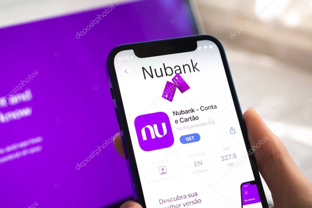 Poltava, Ukraine - April 5, 2022: Nubank app icon. Hand with mobile phone with application. Mobile banking concept