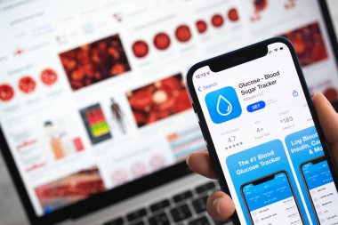 Glikoz Kan şekeri takip uygulaması simgesi. Uygulama izleyici fotoğraflı cep telefonu kullanan kadın