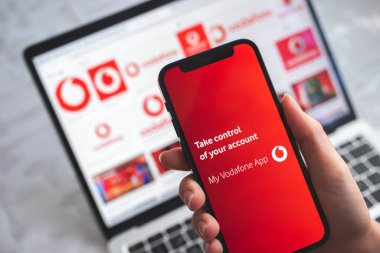 Vodafone uygulamam. Mobil ağın başlık ekranlı cep telefonu kadının elinde