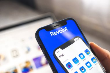 Kadın Revolut uygulaması kullanıyor. Cep telefonu bankacılığı ve yatırım konsepti fotoğrafı