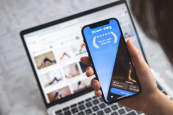 Mladá žena používat Jóga Down Dog mobilní app logo na obrazovce mobilního telefonu, zblízka ikona — Stock fotografie