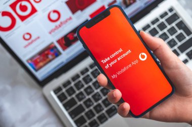 Vodafone uygulamam. Mobil ağın başlık ekranlı cep telefonu kadının elinde
