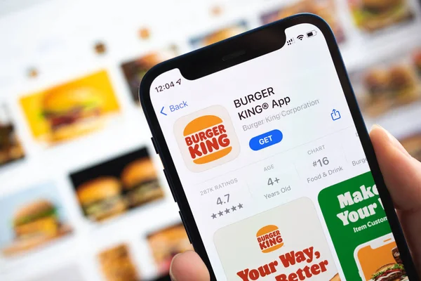 App-Symbol von Burger King. Hand mit Handy mit Applikation. Fast-Food-Konzept Foto — Stockfoto