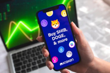 Poltava, Ukrayna - 7 Nisan 2022 Kraken kripto para birimi cüzdanı uygulaması. Akıllı telefonlu el, ekranda logo. Stok şeması arkaplanı