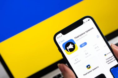 Poltava, Ukrayna - 8 Nisan 2022: Cep telefonu için Air Raid Siren uygulaması. Ukrayna için modern hava alarmı uygulamalı akıllı telefon. Arkaplanda bayrak