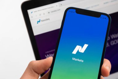 SPB, Rusya - 25 Nisan 2022: Adam cep telefonu ekranında Nasdaq pazarını kullanıyor. Finans borsası