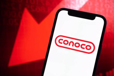 Conoco petrol fiyatları, yakın plan logo. Çöküş, petrol krizi, borsa grafiklerinde kırmızı ok.