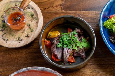 Restoranda nefis ve lezzetli yemekler. Ahşap masada lezzetli bir yemek tabağı. Gurme mutfağı, öğle yemeği, akşam yemeği, güzel, modern