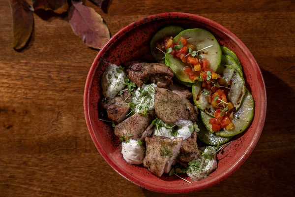 Restoranda nefis ve lezzetli yemekler. Ahşap masada lezzetli bir yemek tabağı. Gurme mutfağı, öğle yemeği, akşam yemeği, güzel, modern. Soslu ve sebzeli ızgara tavuk parçaları.