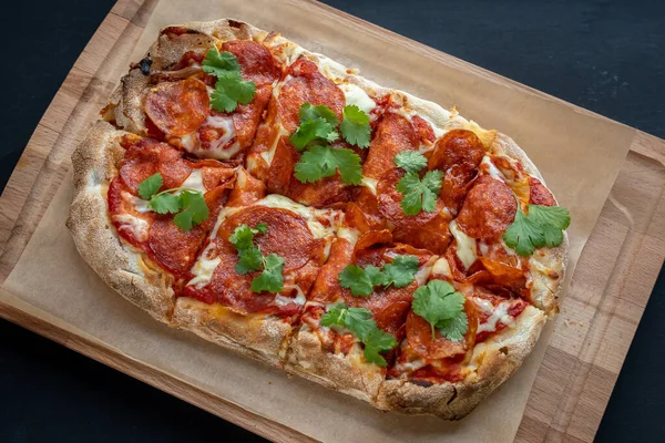 Siyah arka planda lezzetli pizza. Lezzetli biberli pizza. Arkadaşlarla vakit geçirmek ve lezzetli yemekler yemek..