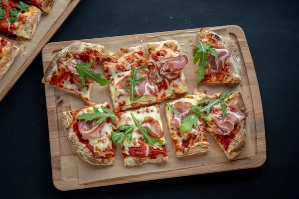Siyah arka planda lezzetli pizza. Pastırma ve peynirli lezzetli pizza. Arkadaşlarla vakit geçirmek ve lezzetli yemekler yemek..