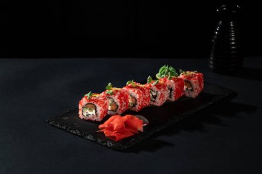 Taze balıklı suşi rulosu, avokado, siyah arka planda krem peynir. Suşi menüsü. Japon yemeği..