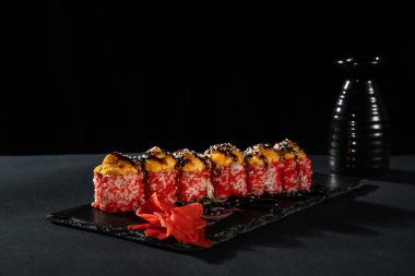 Taze balıklı suşi rulosu, avokado, siyah arka planda krem peynir. Suşi menüsü. Japon yemeği..