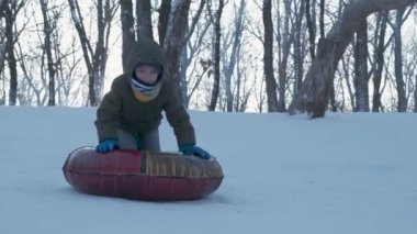 Dışarıda karla oynayan gülümseyen çocuklar. Çocuk tatilde ve tatilde arkadaşlarıyla kış parkında eğleniyor. Duygu, mutluluk, yaşam tarzı konsepti. Yokuşta snowboardcu