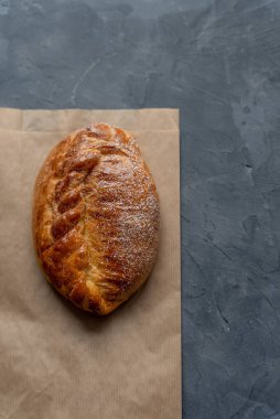 Bakery pastries on grey background. Freshly cooked bakery with cherry for delivery or take away. Home cooked bakery for morning breakfast. Copy space. Vertical shot. Selective focus