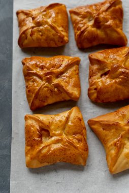Bakery pastries on white and grey background. Freshly cooked bakery. Home cooked bakery for morning breakfast. Copy space. Vertical shot. Selective focus