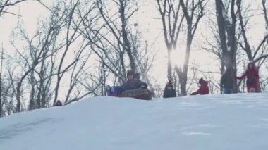 Dışarıda karla oynayan gülümseyen çocuklar. Çocuk tatilde ve tatilde arkadaşlarıyla kış parkında eğleniyor. Duygu, mutluluk, yaşam tarzı konsepti. Yokuşta snowboardcu