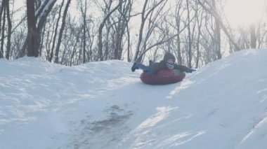 Dışarıda karla oynayan gülümseyen çocuklar. Çocuk tatilde ve tatilde arkadaşlarıyla kış parkında eğleniyor. Duygu, mutluluk, yaşam tarzı konsepti. Yokuşta snowboardcu