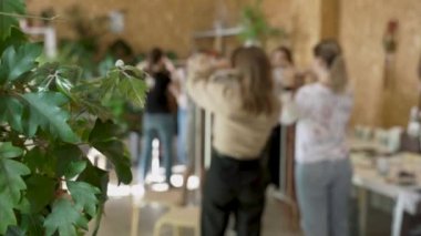 Sanat dersine katılan bir grup kadın. Bayan öğrenciler ve öğretmen birlikte atölyede Boho stilinde ev dekorasyonu yapıyorlar. Sanat okulu stüdyosunda el yapımı makrome örüyor. Yaratıcılık, insanların eğitimi