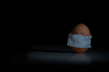 Corona virüsü COVID19 korumalı Paskalya yumurtaları. Paskalya tatili dekorasyonu için maske takarak kendin yap. Seçici odak noktası COVID-19 koruması.