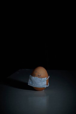 Corona virüsü COVID19 korumalı Paskalya yumurtaları. Paskalya tatili dekorasyonu için maske takarak kendin yap. Seçici odak noktası COVID-19 koruması.