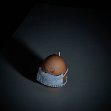 Corona virüsü COVID19 korumalı Paskalya yumurtaları. Paskalya tatili dekorasyonu için maske takarak kendin yap. Seçici odak noktası COVID-19 koruması.