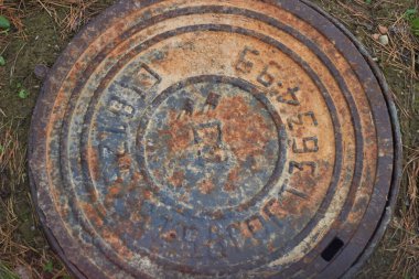 Paslı rögar kapağı yeraltı kapısı olan grunge rögar kapağı.