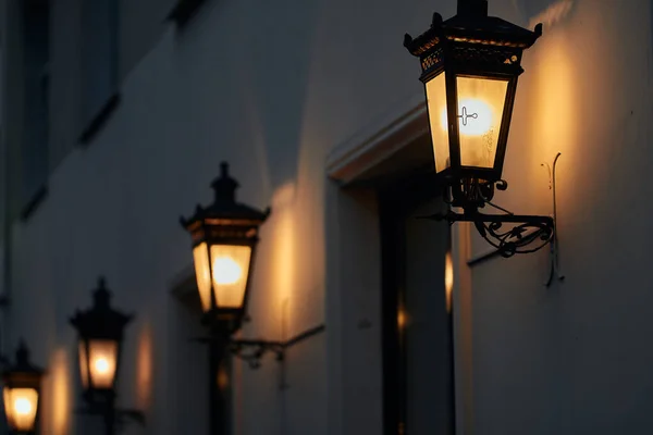 Een decoratieve straatlamp geplaatst in een openbaar park wordt geschonden door een bladerdak van een nabijgelegen boom — Stockfoto