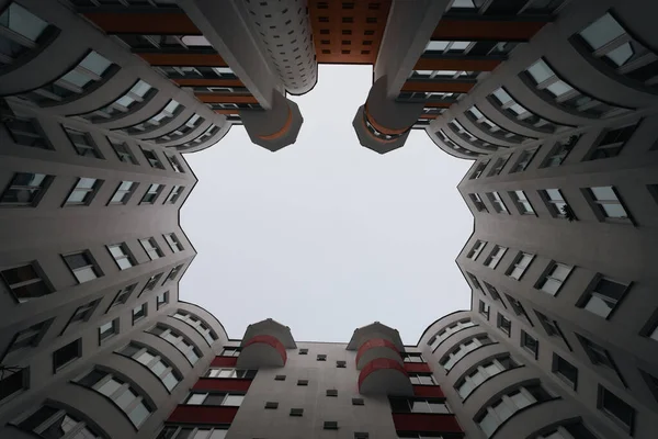 Vista in basso di nuvole grigie in cielo tra vecchia casa di mattoni nella grande città in inverno sera cortile-bene — Foto Stock