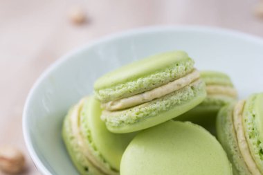 Açık yeşil şam fıstığı aromalı, ahşap arka planda makaronlar.