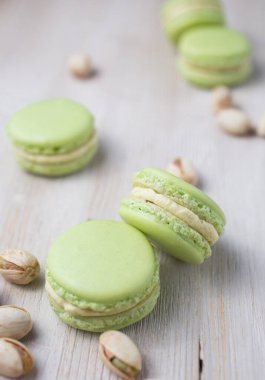 Açık yeşil şam fıstığı aromalı, ahşap arka planda makaronlar.