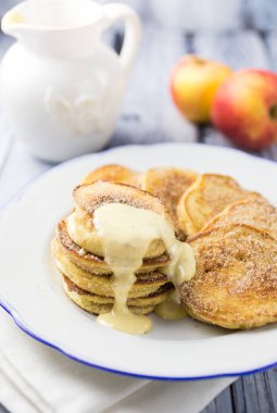 Vanilyalı muhallebi ile servis edilen şekerle kaplı bir tabak elmalı gözleme.