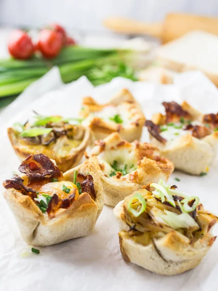 Farklı dolgularla dolu küçük ekmek bardakları.