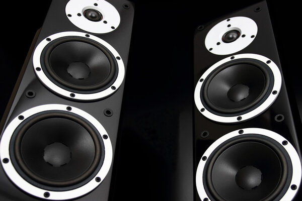 Pair of black glossy audio speakers isolated on black background