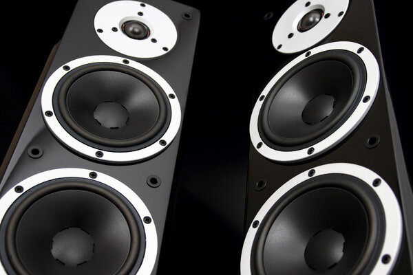 Pair of black glossy audio speakers isolated on black background