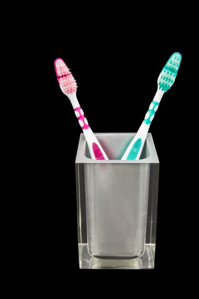 Dos cepillos de dientes en un recipiente semi transparente —  Fotos de Stock