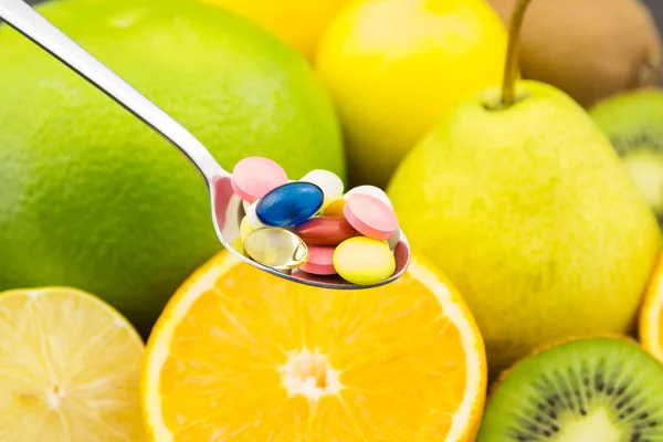 Spoon full of colorful pills — Stock Photo, Image