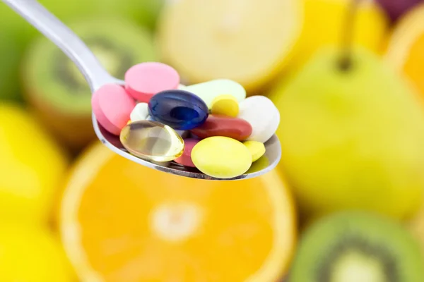 Spoon full of colorful pills — Stock Photo, Image